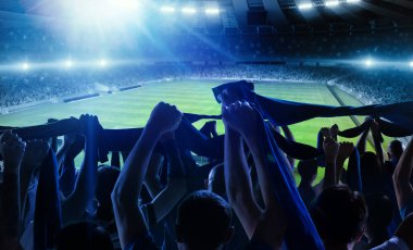 Futbolun arka görüntüsü, futbol taraftarları akşam vakti kalabalık stadyumda eşarplarıyla takımlarına tezahürat yapıyorlar. Spor anlayışı, destek, rekabet. Odaklanma efekti