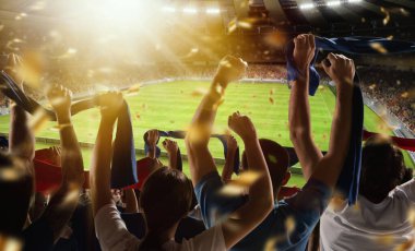 Futbolun arka görüntüsü, futbol taraftarları akşam vakti kalabalık stadyumda eşarplarıyla takımlarına tezahürat yapıyorlar. Spor anlayışı, destek, rekabet. Odaklanma efekti