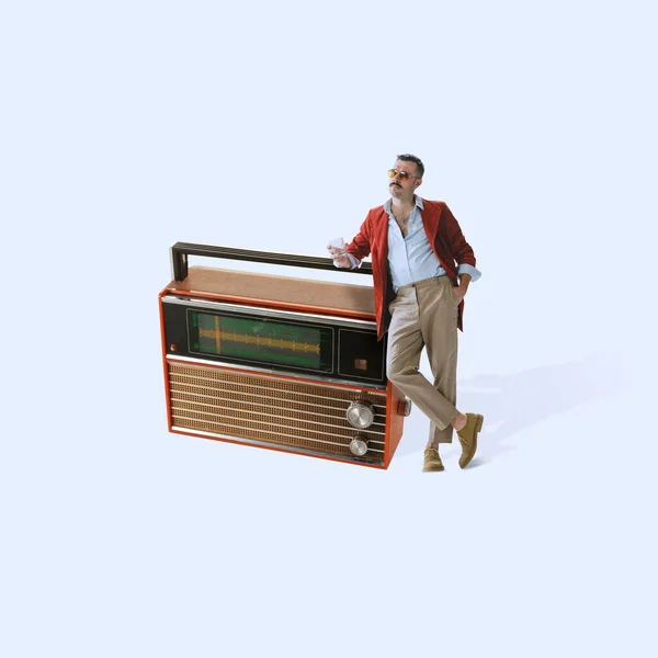 Κολάζ σύγχρονης τέχνης. Κομψός κτηνώδης άντρας που γέρνει στο ρετρό ραδιόφωνο, ακούει μουσική, έχει χαλάρωση απομονωμένη σε ανοιχτό μωβ φόντο — Φωτογραφία Αρχείου