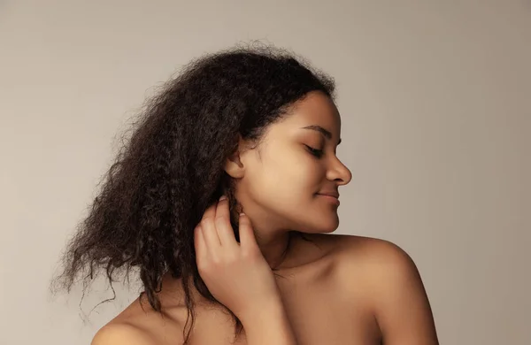 Close-up retrato de jovem mulher bonita com cabelo encaracolado natural posando isolado sobre fundo cinza — Fotografia de Stock