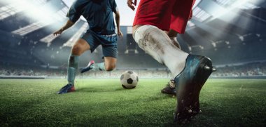 İki futbol oyuncusunun hareket halindeki görüntüsü, futbol maçı sırasında stadyumda hareket. Spor anlayışı, rekabet, hedefler