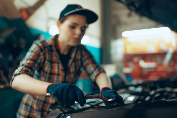 消除性别陈规定型观念。在汽车维修站工作的年轻女性汽车技师使用不同的工作工具。两性平等。工作、职业、汽车 — 图库照片