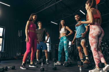 Spor yapan bir grup genç arkadaş, spor salonunda antrenman yapıyorlar. Isınıyorum. Eğitim oturumuna hazırlanılıyor