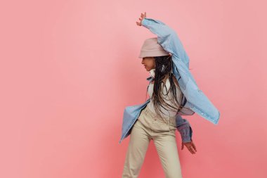 Pembe arka planda izole edilmiş, gündelik giysili kadın modelinin modaya uygun portresi. Güzellik, sanat, moda, gençlik kavramı