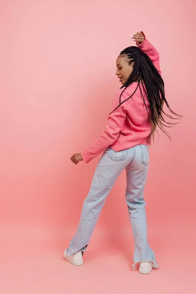 Studioaufnahme eines jungen aufgeregten Mädchens mit Afro-Frisur im lässigen Outfit, das isoliert auf rosa Hintergrund Spaß hat. Konzept von Schönheit, Kunst, Mode, Jugend, Stil — Stockfoto
