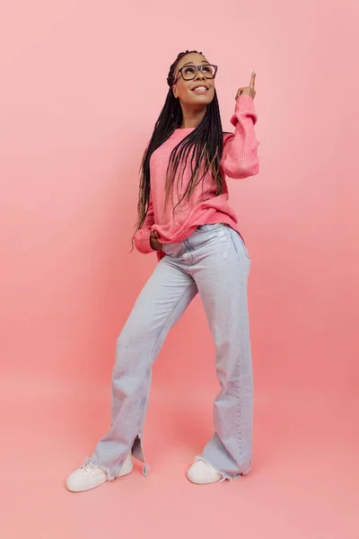 Menina bonita nova com penteado afro em roupa de estilo casual posando isolado no fundo rosa. Conceito de emoções, beleza, arte, moda, juventude, estilo — Fotografia de Stock