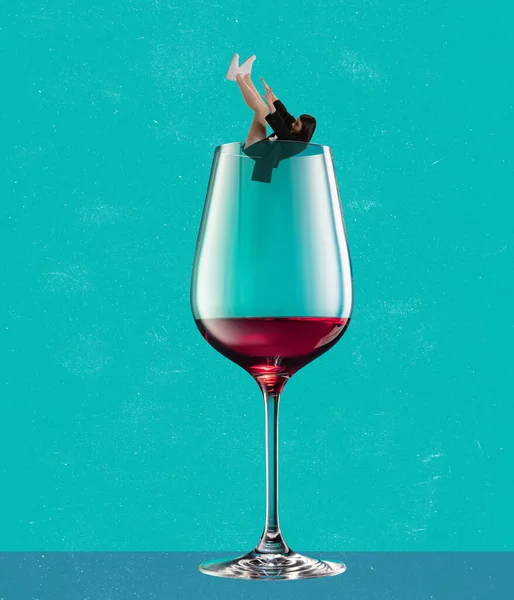 Contemporary art collage. Young woman falling into glass of red wine isolated over blue background — стоковое фото