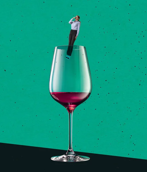 Contemporary art collage. Young woman jumping into glass of red wine isolated over green background — ストック写真