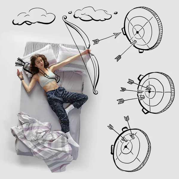 Creative image. Young woman lying on bed, sleeping, dreaming about shooting a bow on target. Top view — Photo