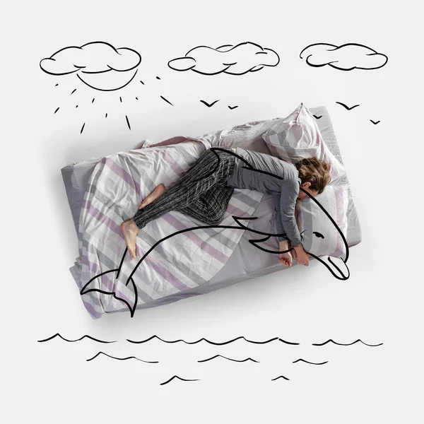 Imagen creativa. Vista superior de la mujer joven acostada en la cama, durmiendo, soñando con un delfín abrazo —  Fotos de Stock