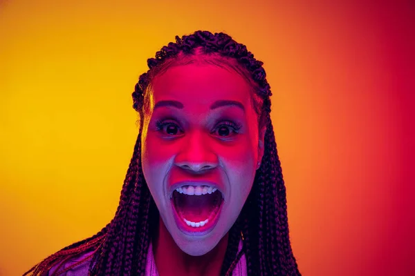 Closeup portrait of shouting isolated on gradient yellow pink background in neon light. Concept of beauty, art, fashion, youth and emotions — Stockfoto