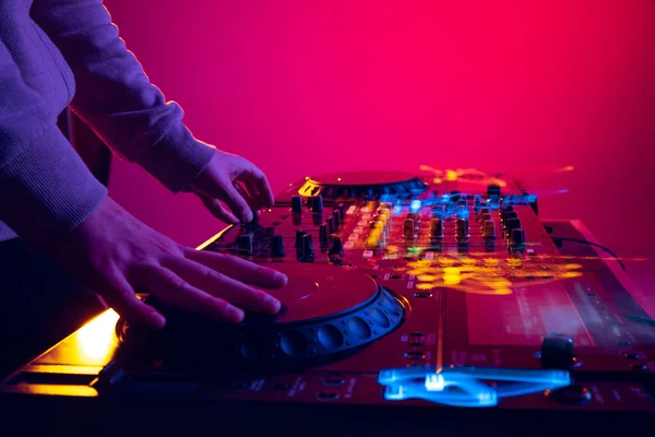 Close-up image of male hands, dj making sounds at night club party with professional sound mixer. Modern performance — Foto de Stock