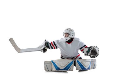 Genç bir çocuğun portresi, hareket halindeki hokey oyuncusu, beyaz stüdyo arka planında izole edilmiş eğitim.