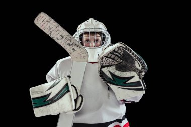 Çocuk portresi, özel koruyucu üniformalı çocuk, eldiven ve eldiven içinde hokey sopası ile siyah stüdyo arka planında izole edilmiş.