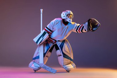 Genç hokey oyuncusunun portresi, kaleci eğitimi, Puck 'ı yakalama mor arka planda izole edilmiş neon ışıkta