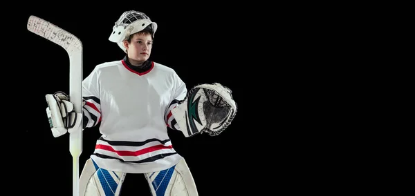 Portrait of young by, teen hockey player, goalkeepr training, posing isolated over black studio background — 스톡 사진