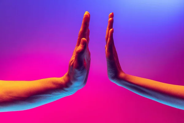 Pray for peace. Human hands gesturing on gradient blue and purple background in neon. Concept of human rights, social issues, gathering. — стоковое фото