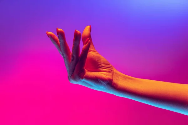 Human hand gesturing isolated on gradient purple-pink background in neon light. Concept of sign language, creativity, symbolism, culture and art — 스톡 사진