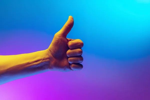 Human hand gesturing isolated on gradient purple-blue background in neon light. Concept of sign language, creativity, symbolism, culture and art — Photo