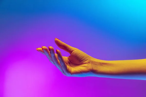 Studio shot of aethentic human hand isolated on gradient purple-blue background in neon light. Concept of human relation, community, togetherness — 스톡 사진