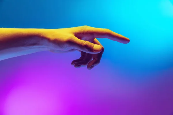 Studio shot of aethentic human hand isolated on gradient purple-blue background in neon light. Concept of human relation, community, togetherness — стоковое фото