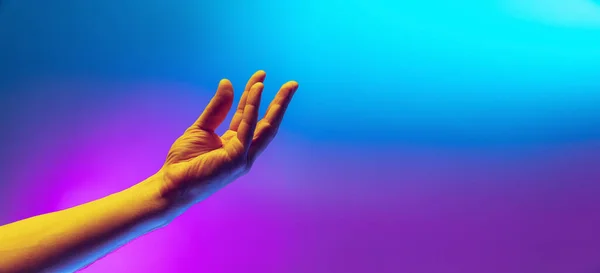Studioaufnahme einer ätherischen menschlichen Hand isoliert auf violett-blauem Hintergrund in Neonlicht. Konzept menschlicher Beziehung, Gemeinschaft, Zusammengehörigkeit — Stockfoto