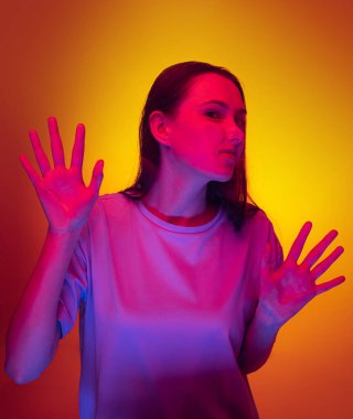 Genç komik kız, sarı arka planda şeffaf cama yaslanmış bir öğrenci. Yakın plan..