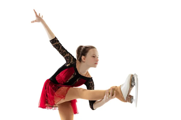 Portrait of little flexible girl, figure skater wearing stage attire posing isolated on white studio background. Concept of movement, sport, beauty. — Photo