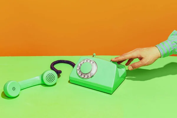 Colorful bright image of old-fashioned green colored phone isolated over orange background — Stock Photo, Image