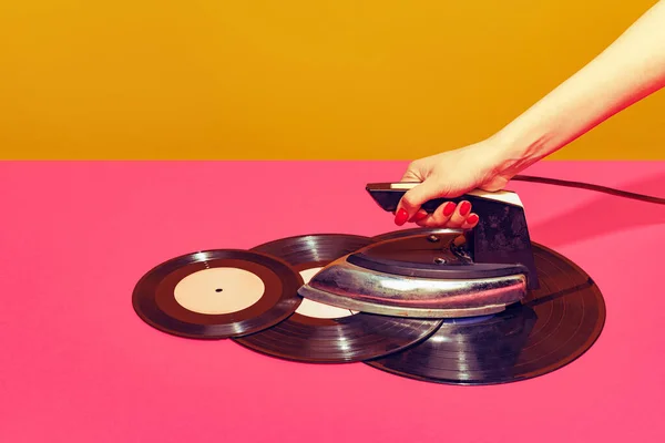 Colorful bright image of woman using retro iron and ironing vintage vinyl records isolated over pink background. Creativity — 스톡 사진