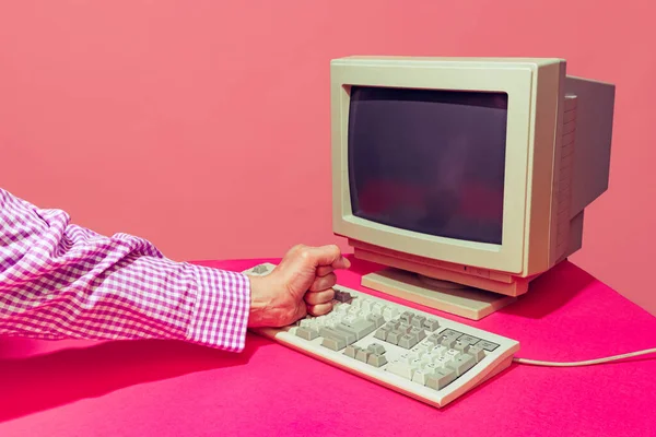 Colorful image of vintage computer monitor and keyboard isolated over bright pink background — Foto Stock