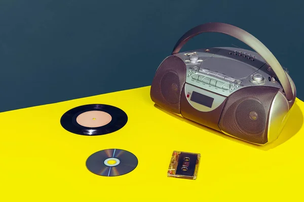 Colorful image of vintage radio player on bright yellow tablecloth isolated over dark green background — 스톡 사진