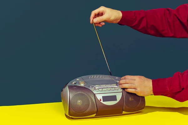 Colorful image of vintage radio player on bright yellow tablecloth isolated over dark green background. Catching radio wave — 스톡 사진
