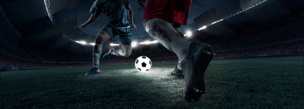 Cropped image of two soccer, football players in motion, action at stadium during football match in evening. Concept of sport, competition, goals — Stock Fotó