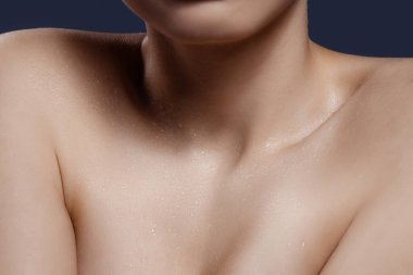 Karanlık stüdyo arka planında izole edilmiş genç kadın modelin yakın portresi. Tarz ve güzellik, cilt bakımı konsepti.