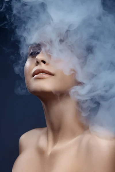 Retrato de menina bonita com pele limpa e bem conservada isolada em fundo escuro com fumaça. Conceito de beleza, arte, anúncio, cosméticos — Fotografia de Stock