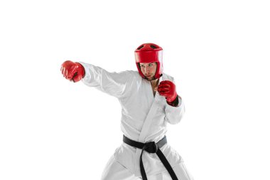 Portrait of young sportive man wearing white dobok, helmet and gloves practicing isolated over white background. Concept of sport, workout, health.