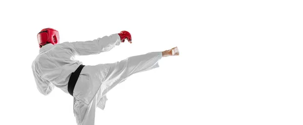 Vista trasera. Retrato de un joven deportista con dobok blanco, casco y guantes practicando aislado sobre fondo blanco. Concepto de deporte, entrenamiento, salud. —  Fotos de Stock