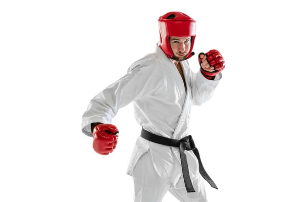 Portrait of young sportive man wearing white dobok, helmet and gloves practicing isolated over white background. Concept of sport, workout, health. — Stock fotografie