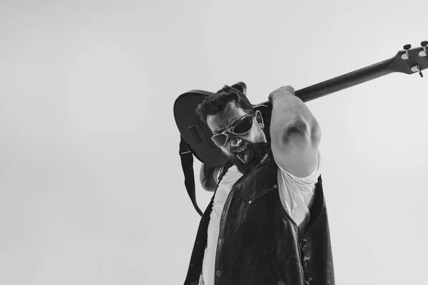 Monochrome. Portrait of stylish young man, rock musician playing electric guitar isolated on white background. Concept of art, music, style —  Fotos de Stock