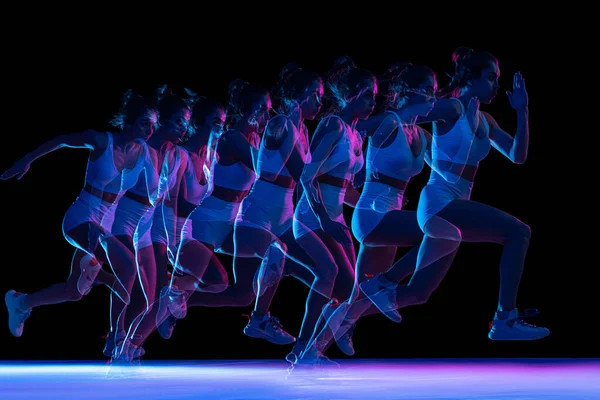 Development of movements. Professional female athlete, runner training isolated on dark background with stroboscope effect. — Stock fotografie