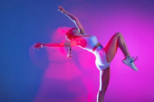 女性アスリートの肖像、混合ピンクのネオンで青のスタジオの背景に隔離されたランナーのトレーニング。健康的なライフスタイル、スポーツ、運動と行動の概念. — ストック写真