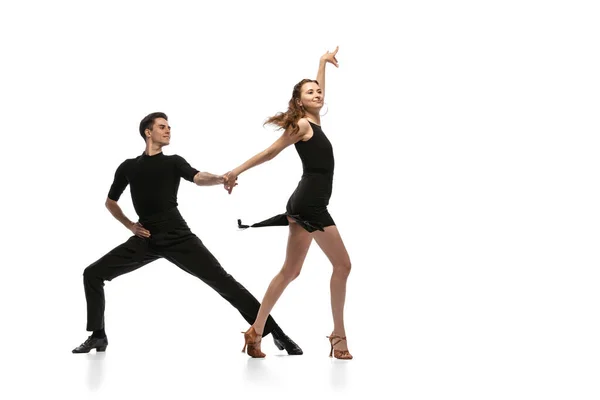 Ritratto dinamico di giovani ballerini emotivi in abiti neri danza da sala isolati su sfondo bianco. Concetto di arte, bellezza, musica, stile. — Foto Stock
