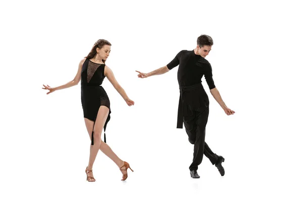 Quickstep. Dynamic portrait of young emotive dancers in black outfits dancing ballroom dance isolated on white background. Concept of art, beauty, music, style. — Fotografia de Stock