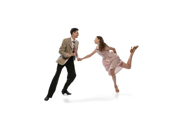 Young man and woman in vintage retro style outfits dancing social dance isolated on white background. Timeless traditions, 1960s american fashion style and art — Stok fotoğraf