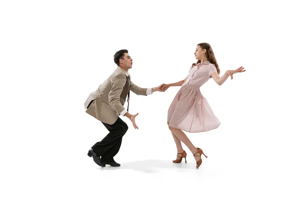 Young man and woman in vintage retro style outfits dancing social dance isolated on white background. Timeless traditions, 1960s american fashion style and art — Stock fotografie