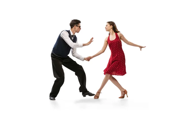 Hermosa chica y hombre con estilo en trajes de estilo retro vintage bailando aislado sobre fondo blanco. Tradiciones atemporales, 60s, 70s estilo y arte americano de la manera — Foto de Stock