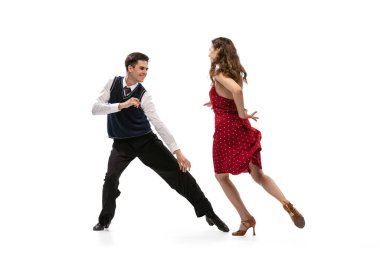 Beyaz arka planda izole bir şekilde dans eden eski moda kıyafetlerle güzel bir kız ve şık bir adam. Zamansız gelenekler, 60 'lar, 70' ler Amerikan moda tarzı ve sanatı