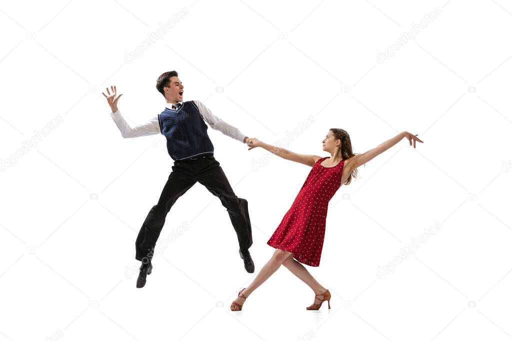 Beautiful girl and stylish man in vintage retro style outfits dancing isolated on white background. Timeless traditions, 60s,70s american fashion style and art