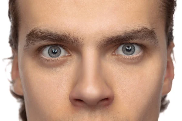 Feche os olhos azuis masculinos do jovem homem bonito isolado no fundo do estúdio branco. Conceito de saúde masculina, visão, autocuidado, medicina e cosméticos. — Fotografia de Stock